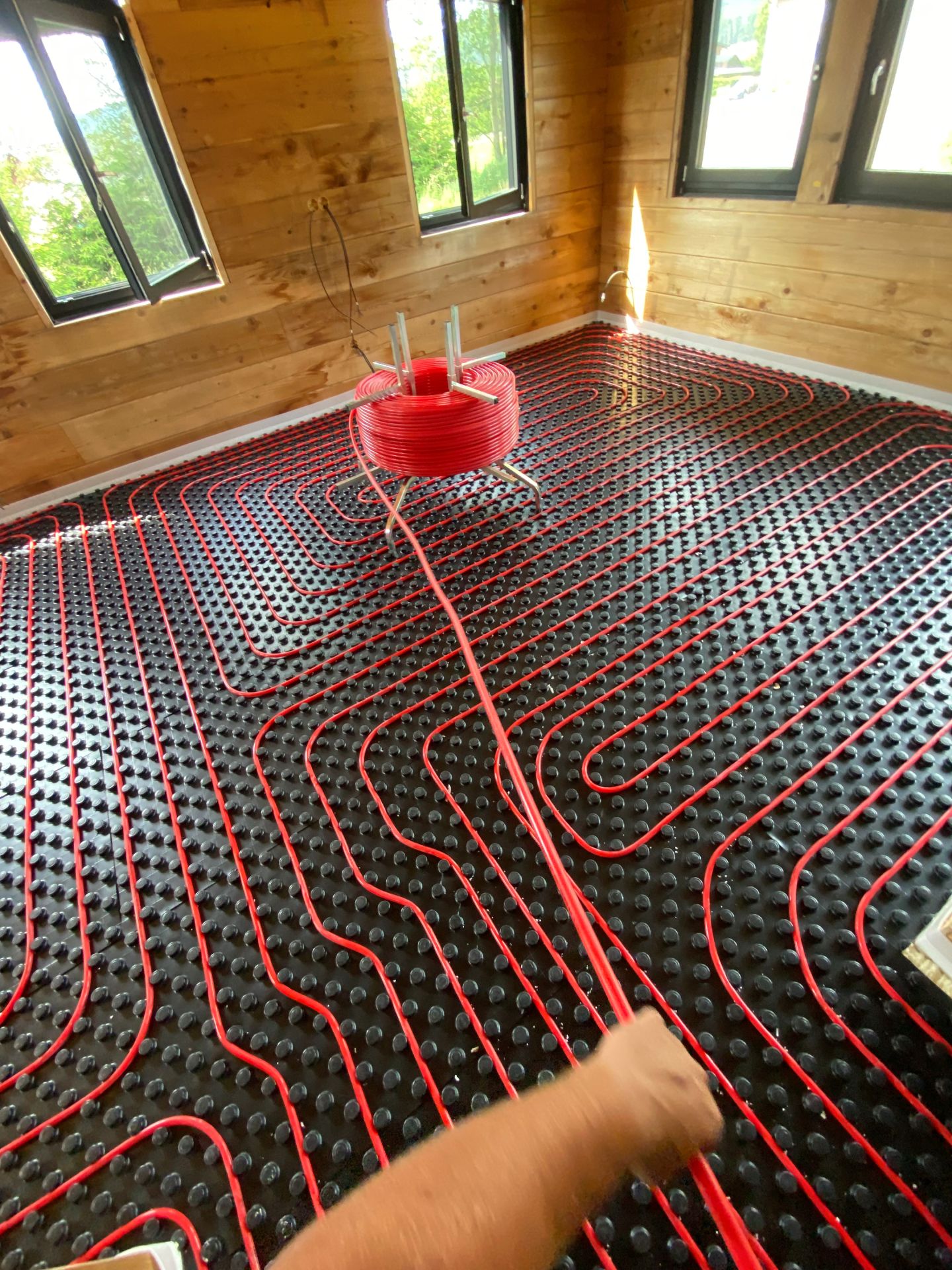 Instalace podlahového topení (systémová deska, červené trubky)